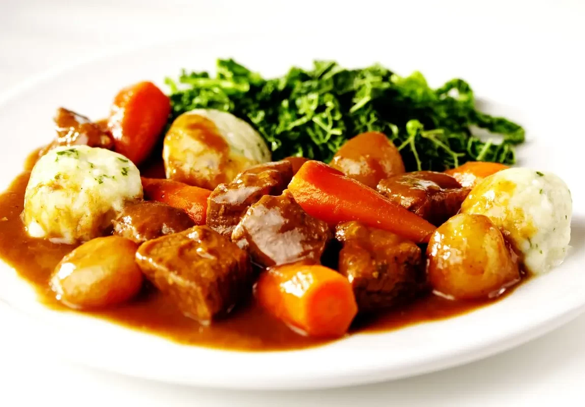 duszone kawałki mięsa z marchewką ziemniakami i sałatą